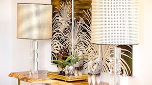 A table with two clear glass lamps, a decorative mirror, and a small plant arrangement. - Santo Thyrso Hotel (Santo Tirso)