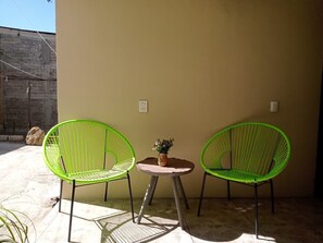A patio with two green chairs and a small table with a plant. - Bokatrip Jalatlaco (Oaxaca)