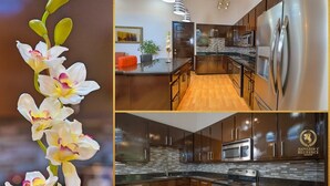 Una cocina moderna con armarios de madera oscura, electrodomésticos de acero inoxidable y piso de madera.
