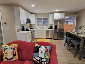 Cozy apartment with a kitchenette and dining area, featuring a sofa and small dining table.