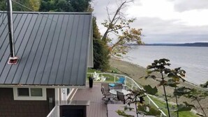 Een huis met een terras met uitzicht op een waterpartij.