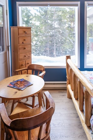 Enjoy meals and social gatherings in this inviting room with a dining table, comfortable seating, and a view of the surrounding landscape.