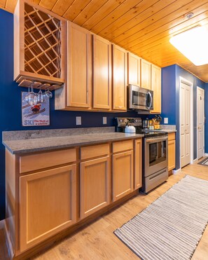 Enjoy cooking in this well-equipped kitchen with a granite countertop, stainless steel appliances, and a wine rack.