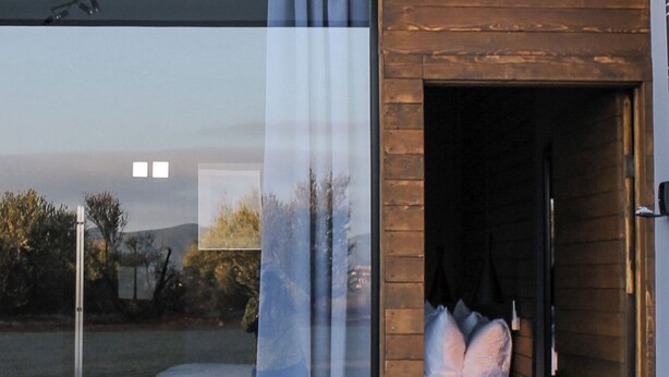 A modern bedroom with a glass door, a bed with pillows, and a view of the outdoors. - Pulso Valle de Guadalupe (Valle de Guadalupe)