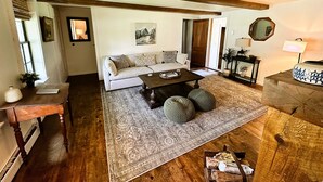 Un salon avec un canapé, une table basse et un plancher en bois.