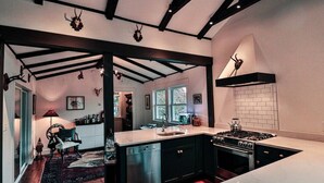 Una cocina moderna con una isla central, armarios oscuros y una estufa.