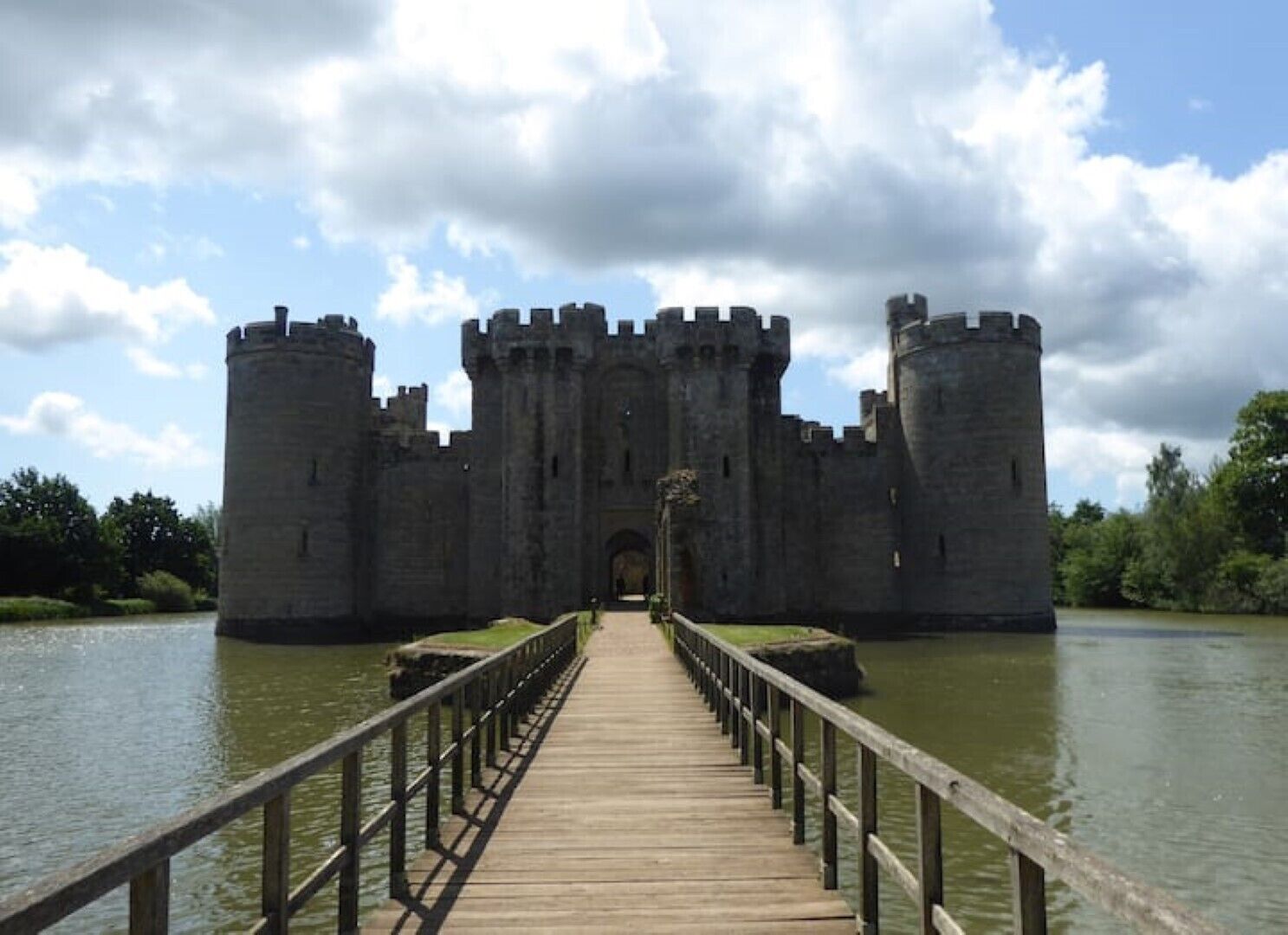 Un castello con un ponte di legno che conduce all'ingresso, circondato dall'acqua.