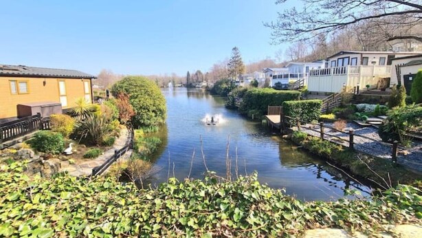 Een rivier met een boot, omringd door begroeiing en gebouwen.