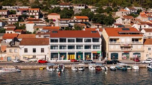 Un pueblo costero con un puerto deportivo, que presenta un edificio de dos plantas con restaurante y mercado.