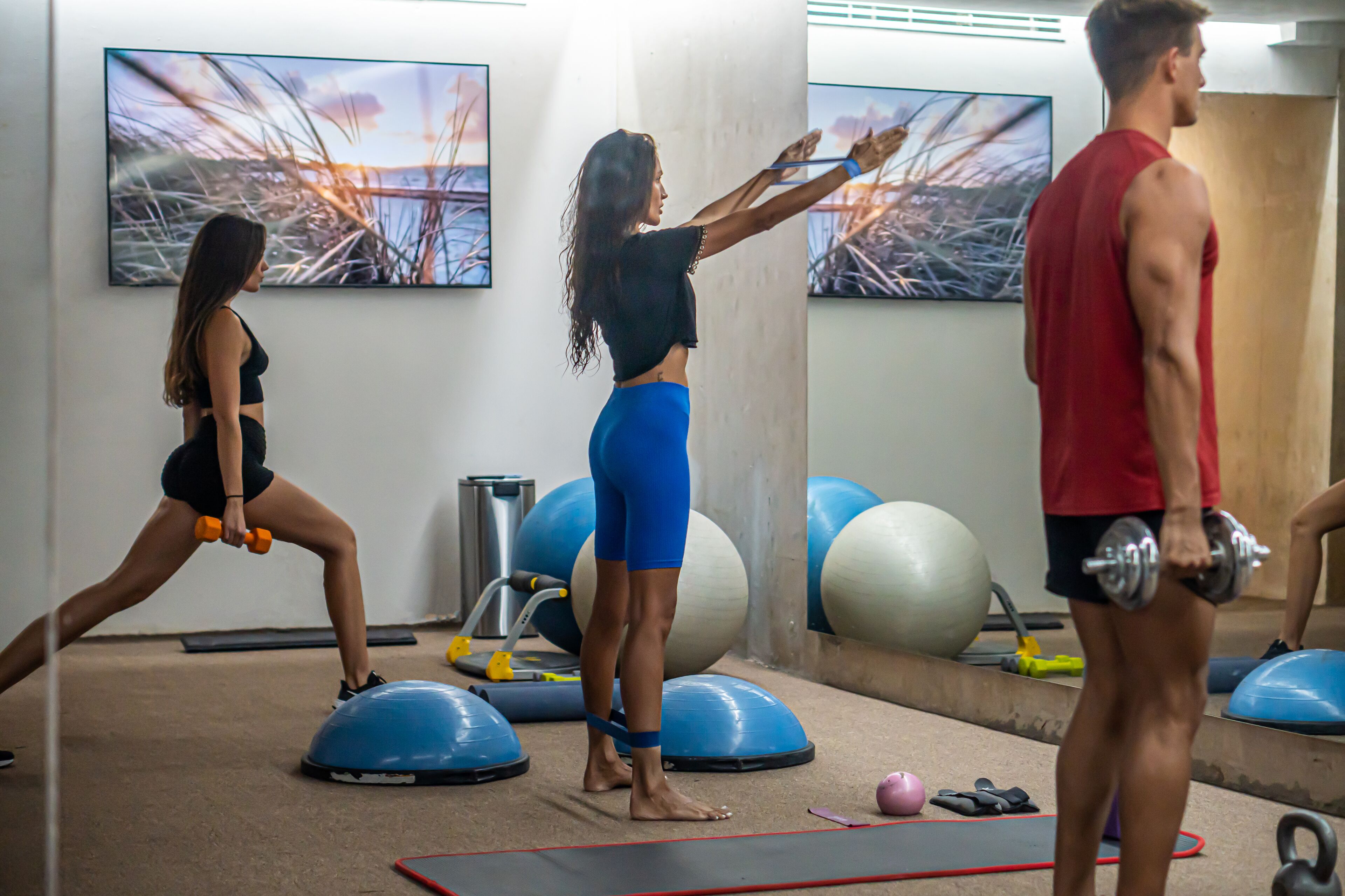 Ein Fitnessstudio mit Trainingsgeräten, Matten und Gymbällen.