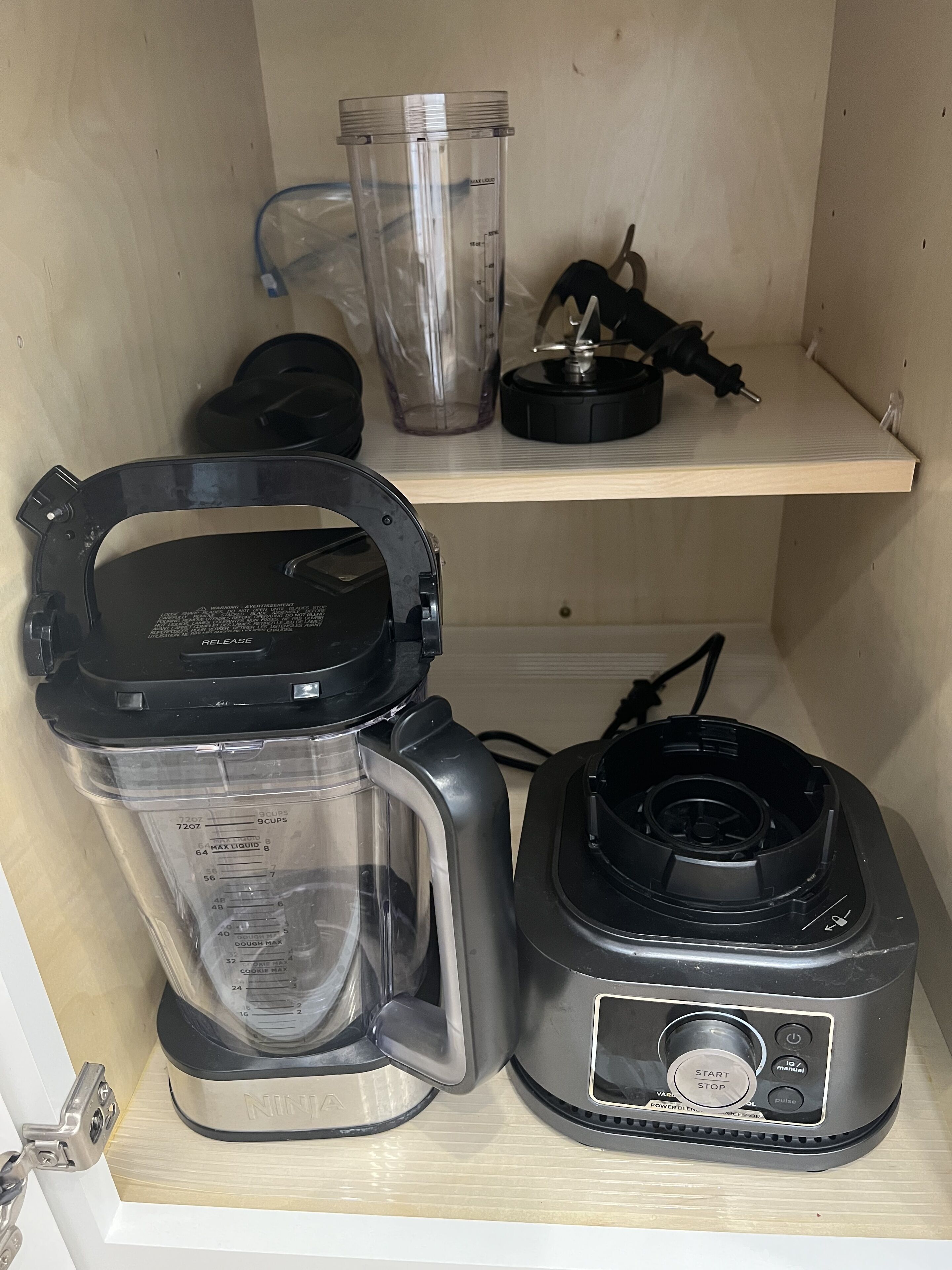 A kitchen with a blender and a coffee maker on the counter.