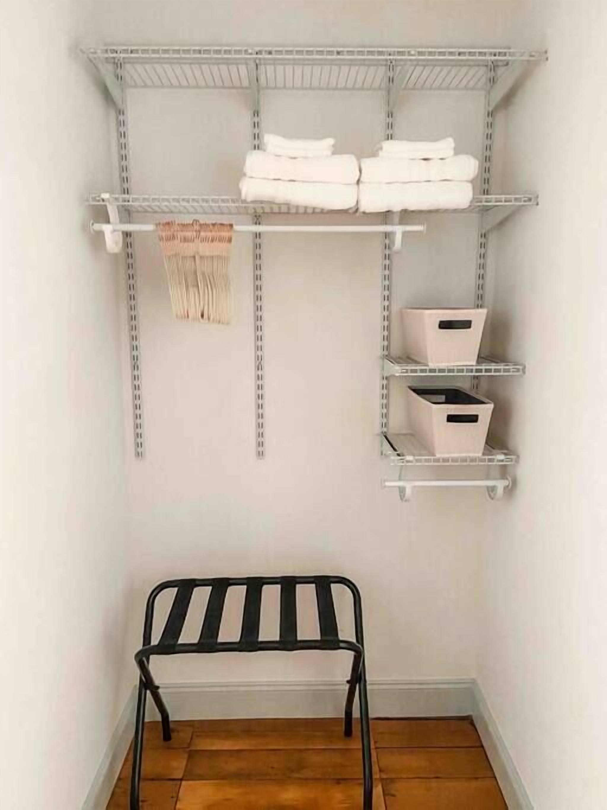 A storage area with metal shelves holding folded towels and storage boxes.