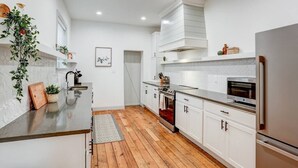 A modern kitchen with white cabinetry, a wooden countertop, and a built-in oven. - Luxury Manor on Mulberry in the heart of Downtown Lanc (Lancaster)