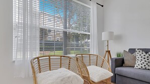 A living room with two wicker chairs, a grey sofa, and a floor lamp. - Newly Renovated First Floor 2Bed & 2 Bath, Near Disney (Kissimmee)