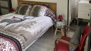 A bedroom with a bed, a chair, a dresser, and a mirror. - LES COMBES apartment-chalet sleeps 4 classified 3 * LES ROUSSES (Les Rousses)