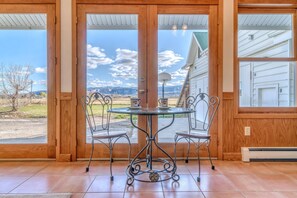 A wooden-framed glass door with a view of a house and landscape. - Shady Acres: Two Living Spaces & Curated Library (Fruita)