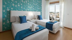 A hotel room with two beds, a view of the city, and a balcony. - Paradise Place - Pool Balcony (Nazaré)
