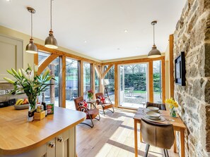 A spacious kitchen with wooden beams, large windows, and a stone wall. - 1 bedroom accommodation in Llandrinod Wells (Llandrinod Wells)