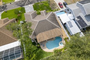 Ein Wohngebiet mit einem Haus, das ein großes, geneigtes Dach und einen Swimmingpool hat.