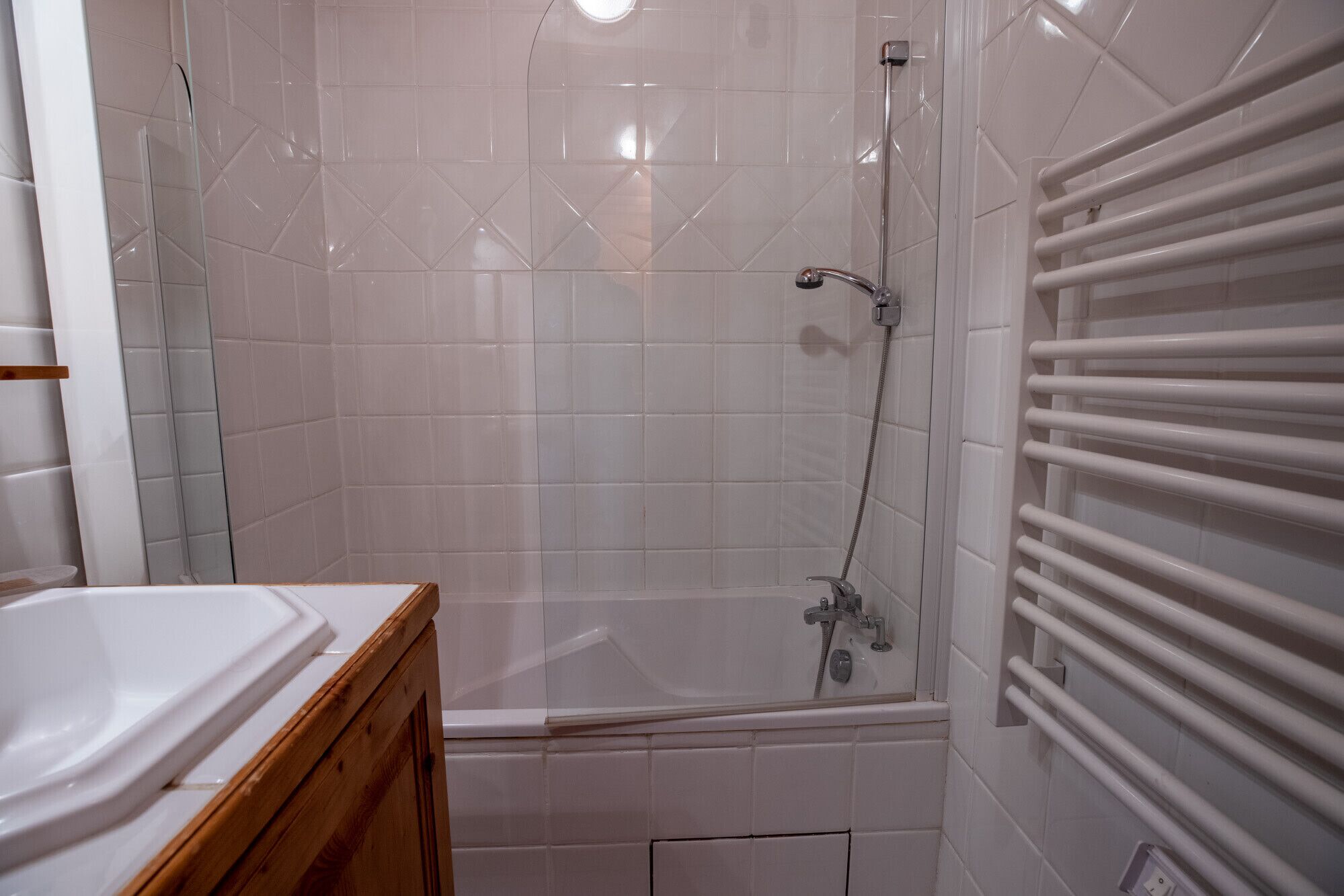 A bathroom with a shower, a bathtub, and a wooden vanity.