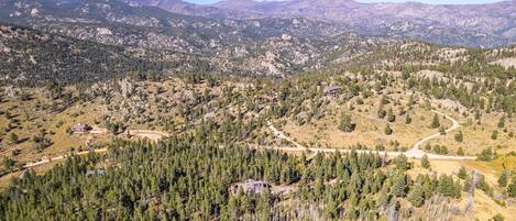 Un paisaje montañoso con casas dispersas y bosques densos.