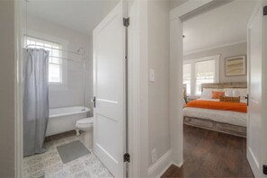 Une salle de bain avec une baignoire, des toilettes et un rideau de douche.
