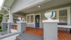 A house with a covered porch, a blue door, and a white exterior.