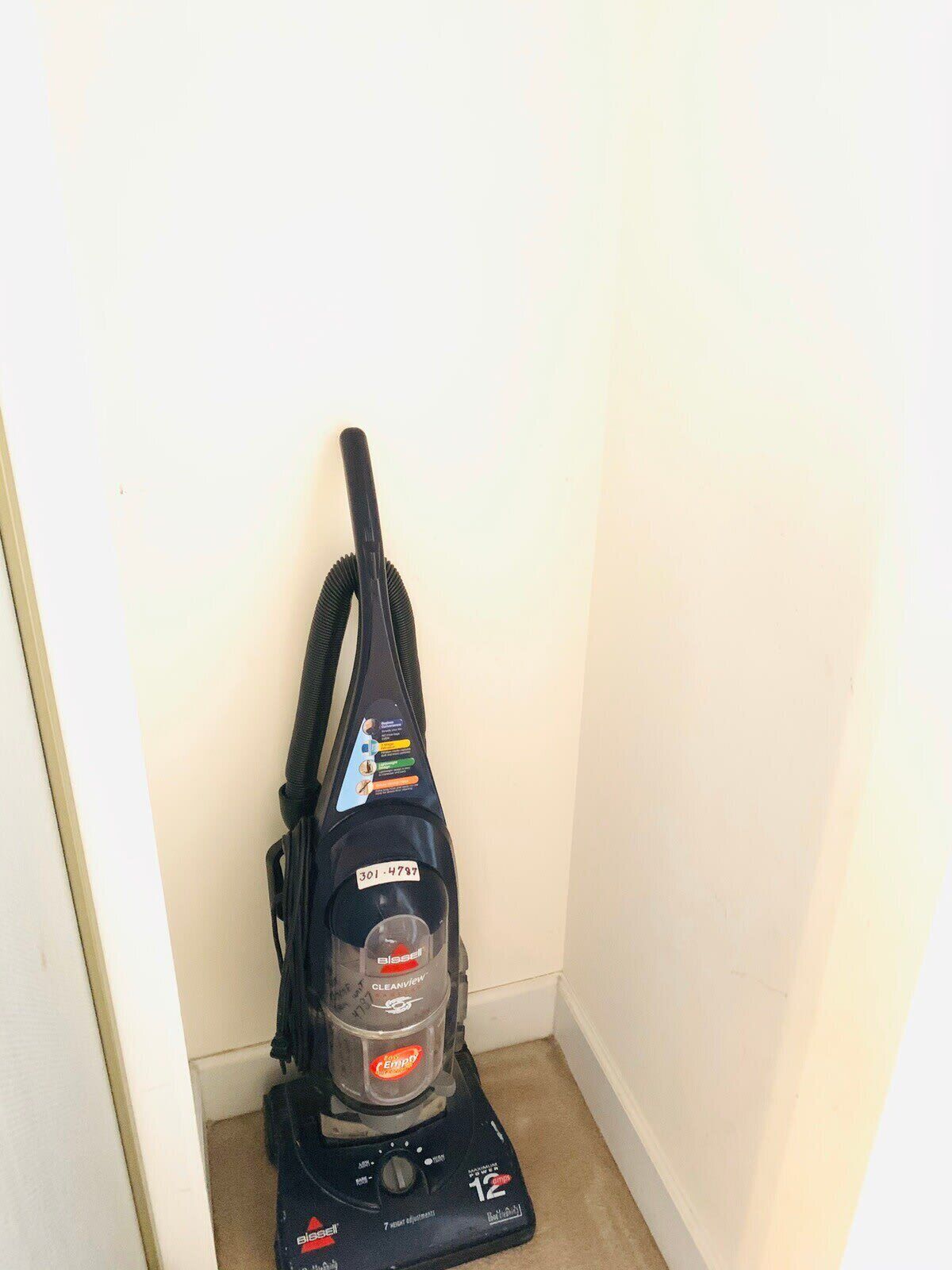 A vacuum cleaner in a corner of a room.
