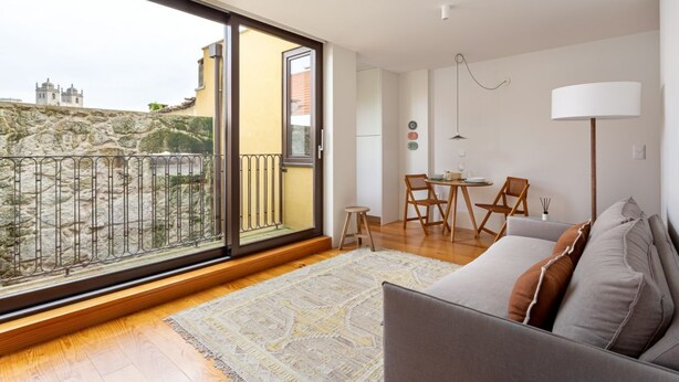 A modern apartment with a balcony, a dining area, and a sofa. - JOIVY Stunning 1-bed flat with balcony (Porto)