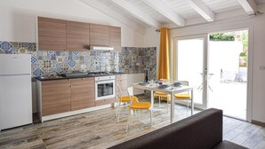 Una cocina moderna con armarios de madera, un salpicadero de azulejos y una zona de comedor con mesa y sillas.