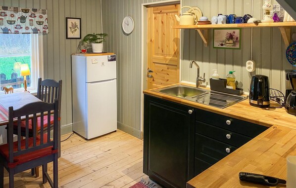 A compact kitchen with a refrigerator, sink, and wooden cabinets. - Gorgeous home in Hok with WiFi (Hok)