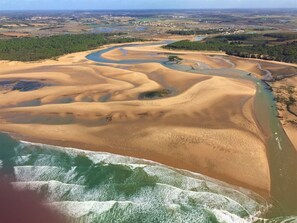 An aerial view of a coastal area with sand dunes, a river, and a forested area in the background. - MAT DE MISAINE - Face à la Plage (Les Sables-d´Olonne)