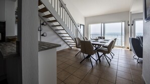 Ein geräumiger Essbereich mit hoher Decke und Meerblick.