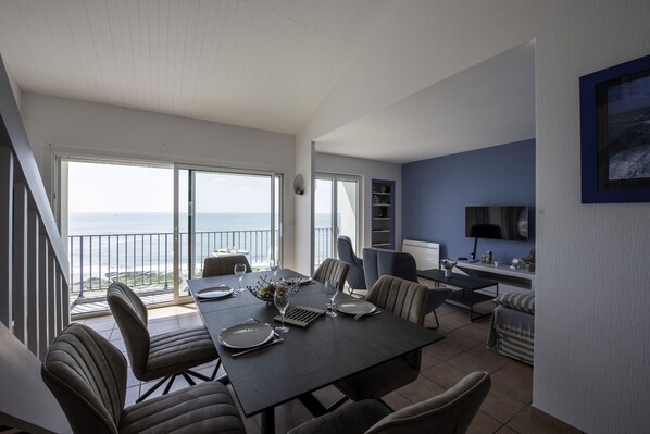 A spacious dining area with a large table, chairs, and a view of the ocean. - MAT DE MISAINE - Face à la Plage (Les Sables-d´Olonne)
