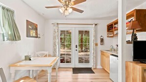 A compact kitchen with a dining area, a ceiling fan, and a view through the glass doors. - Pet friendly Fun Family Cabin- 3 Beds, Fireplace, Horseshoes, Swing, Hottub (Payson)
