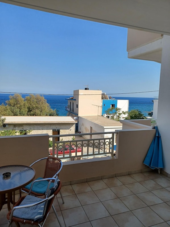 Enjoy the serene sea views from this balcony, featuring a table and two comfortable chairs.