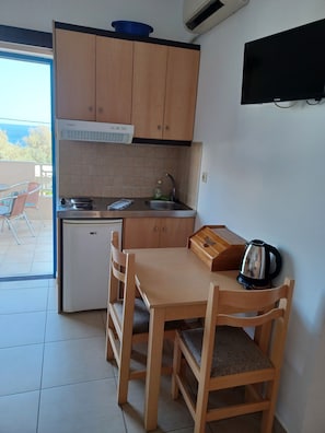 Compact kitchen with stove, refrigerator, and sink, offering a convenient space to prepare meals.