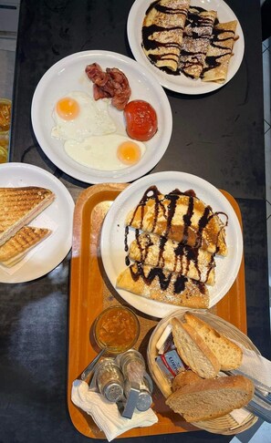 A breakfast tray with pancakes, eggs, bacon, and toast.