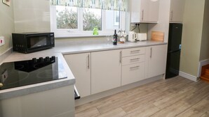 Cocina moderna equipada con microondas, tostadora, hervidor y refrigerador.