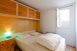 Cozy retreat with a bed, nightstand, and lamp, offering a peaceful space to rest.