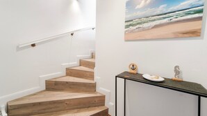 Eine Treppe mit Holzbodenstufen und einer weißen Wand.
