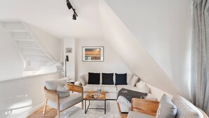 Eine moderne Lofts-Wohnung mit hohen Decken, einer Wendeltreppe, einer Sofagarnitur und einem Couchtisch.