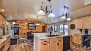 Une cuisine spacieuse avec des meubles en bois, un îlot central et des luminaires suspendus.