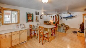 Une cuisine de taille réduite avec un coin repas, des meubles en bois et un ventilateur de plafond.