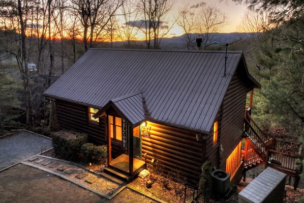 A log cabin with a metal roof, a wooden deck, and a staircase leading to a porch. - Overlook Oasis - Hot tub, firepit, and comfy king beds! (Blue Ridge)