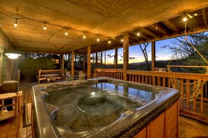 A hot tub area with a wooden deck, outdoor seating, and a view of the landscape. - Overlook Oasis - Hot tub, firepit, and comfy king beds! (Blue Ridge)