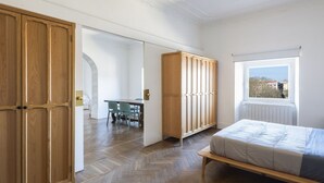 Une chambre à coucher avec un lit, une armoire en bois et une vue par la fenêtre.