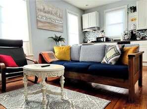Relax in this stylish living room with a sofa, coffee table, and armchair, perfect for unwinding.