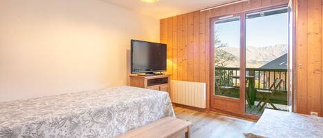 Une chambre à coucher avec un lit, une télévision, un banc et une table.