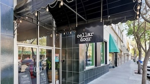 Un escaparate con un letrero que dice 'cellar door' y un tablero de menú visible en el exterior.